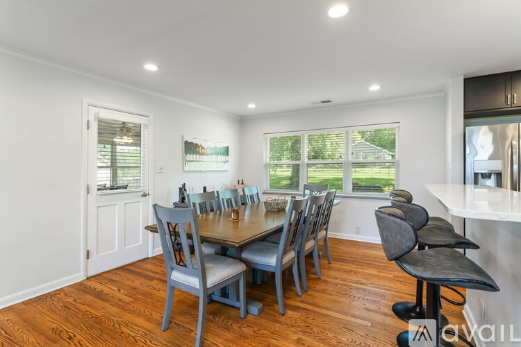 A dining room with a large table and chairs.