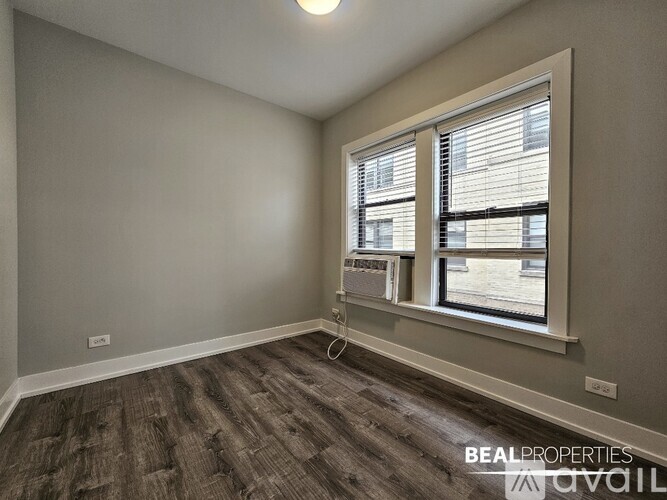 A room with a window and a wall-mounted air conditioner unit.
