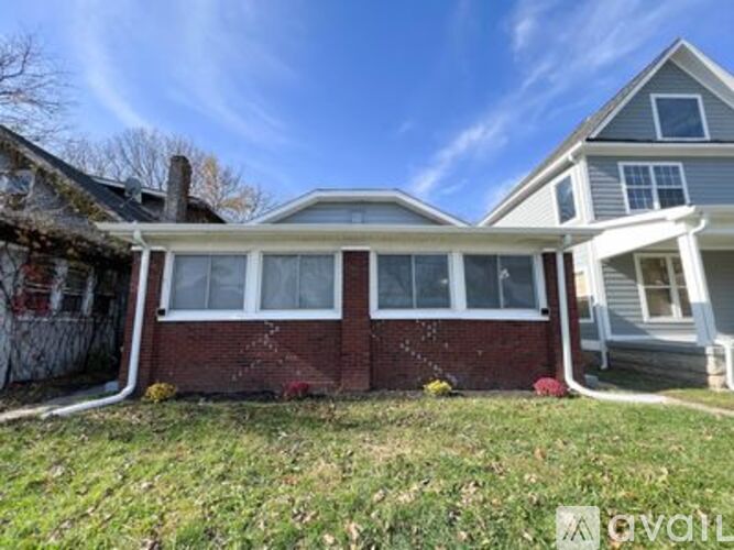 A house with a red brick wall and a white roof.