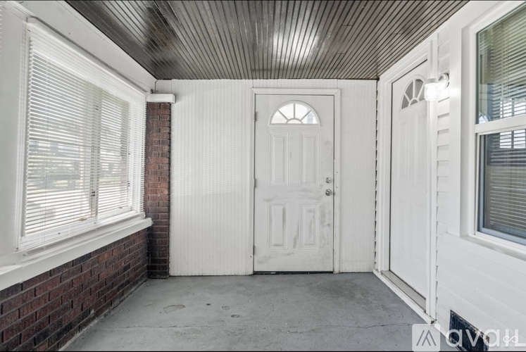 A room with a wooden ceiling and a large window overlooking a street.