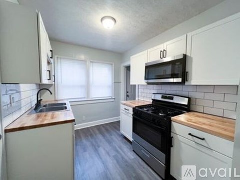 A kitchen with white cabinets and a wooden countertop.