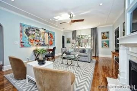 A living room with a fireplace and a painting on the wall.