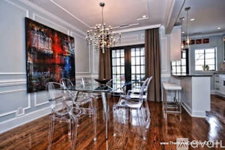 A modern dining room with a glass table and chairs.
