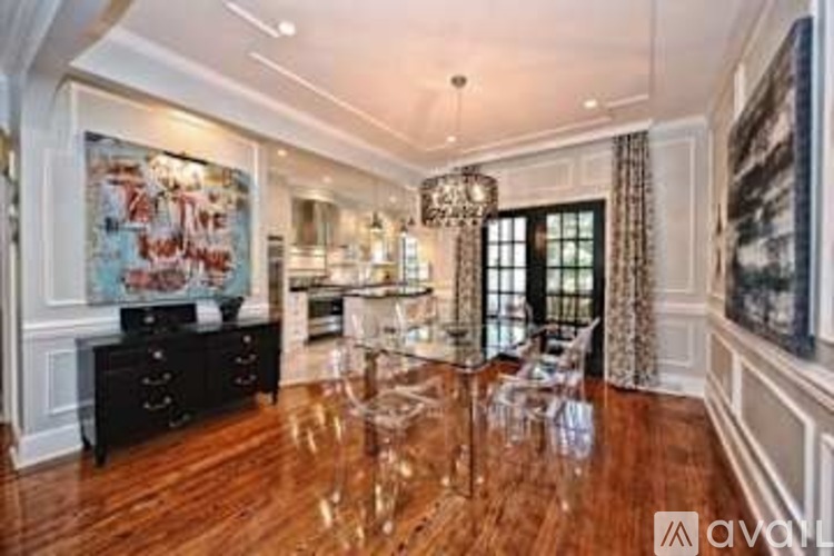 A spacious room with wood floors and a large chandelier.
