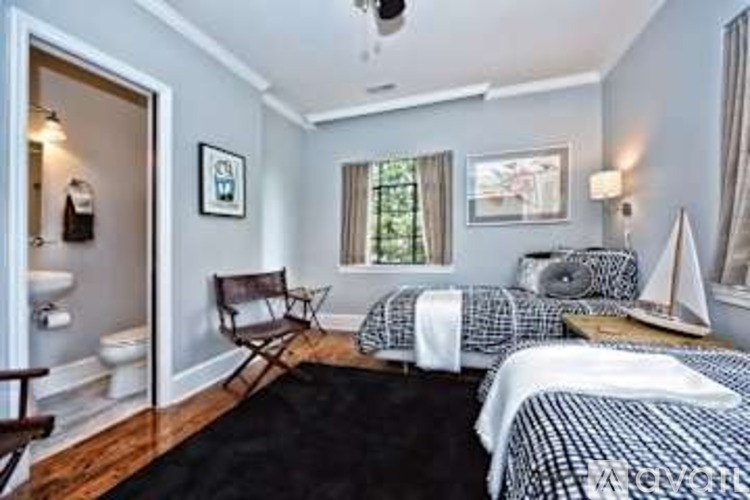 A bedroom with two beds and a chair.