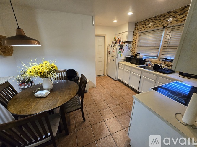 A kitchen with a table and chairs in the foreground and a refrigerator in the background.