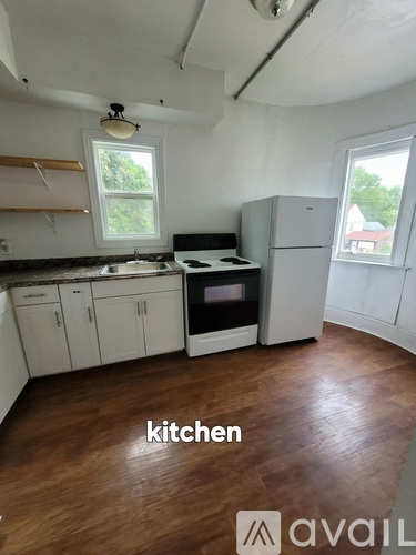 A kitchen with wooden floors and white cabinets.