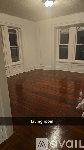 A living room with wood floors and white walls.
