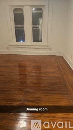 A dining room with wood flooring and a window.