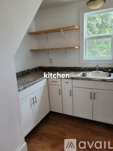 A kitchen with white cabinets and a granite countertop.