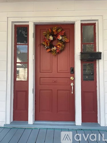 A red door with a wreath on it.