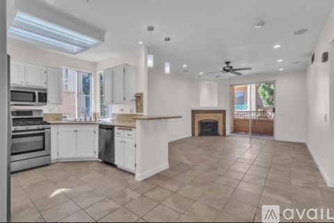 A spacious kitchen with white cabinets and a tiled floor.