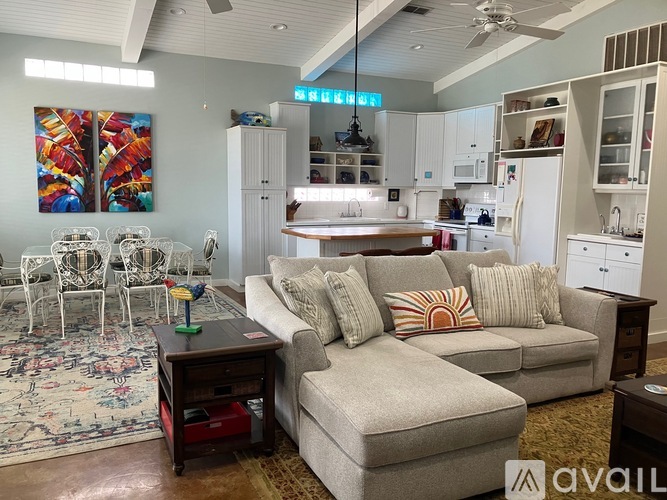 A living room with a grey couch and a rug.