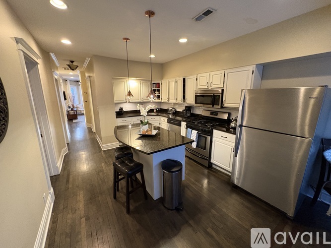 A modern kitchen with a large island and stainless steel appliances.