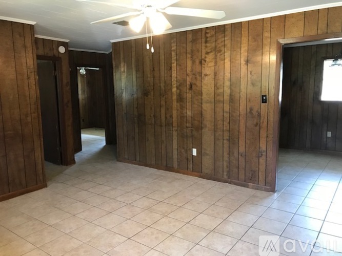 A room with wooden walls and a ceiling fan.