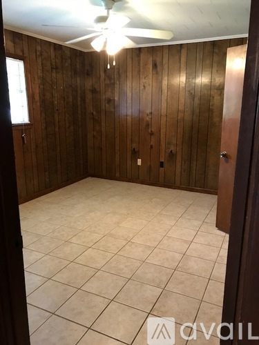 A room with wooden walls and a ceiling fan.