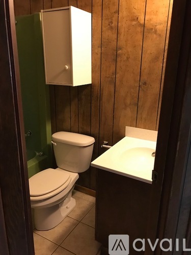 A white toilet sits next to a sink in a small bathroom.
