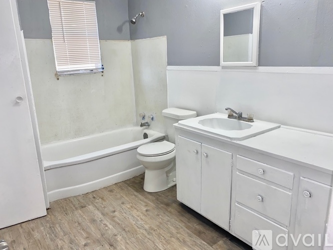 A white bathroom with a toilet, sink, and bathtub.