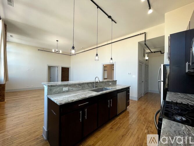 A kitchen with dark wood cabinets and a marble countertop.
