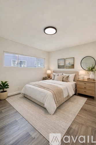A well-lit bedroom with a large bed and a plant.
