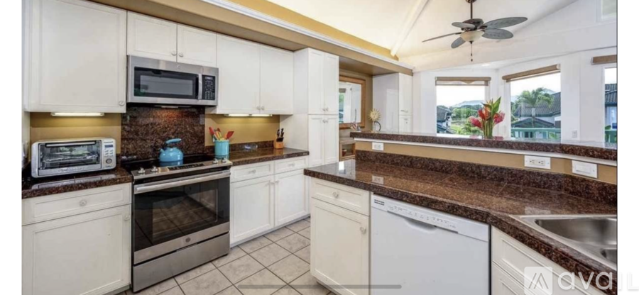 A kitchen with white cabinets and a brown countertop.