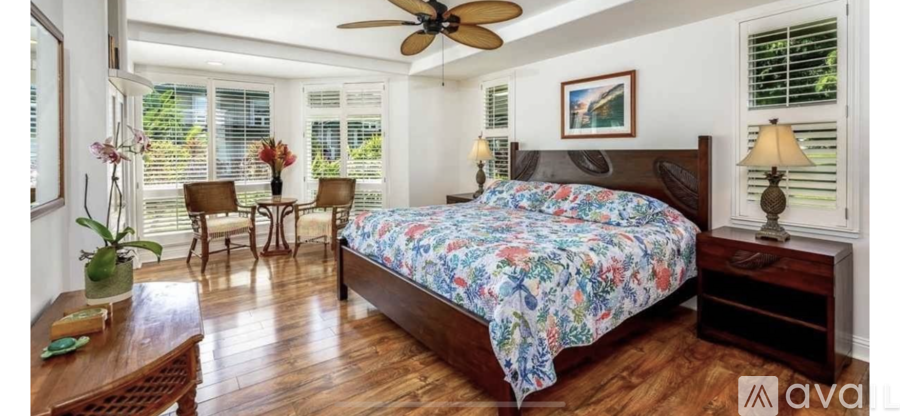 A bedroom with a large bed and a ceiling fan.