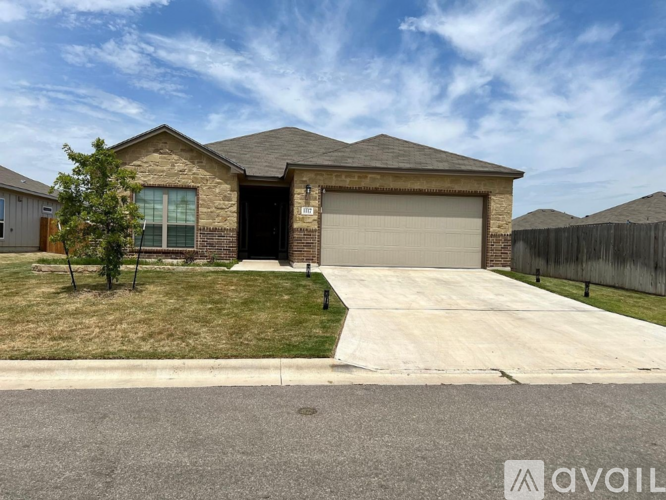 A house with a garage and a driveway in front of it.