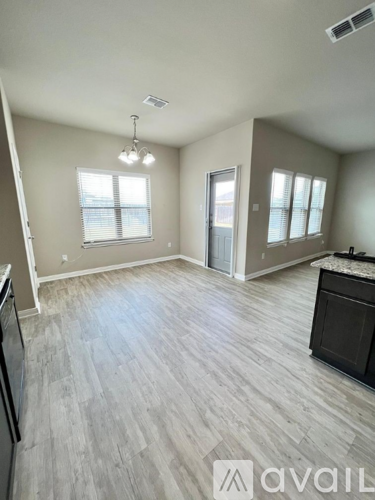 A kitchen with a refrigerator, a counter, and a window.