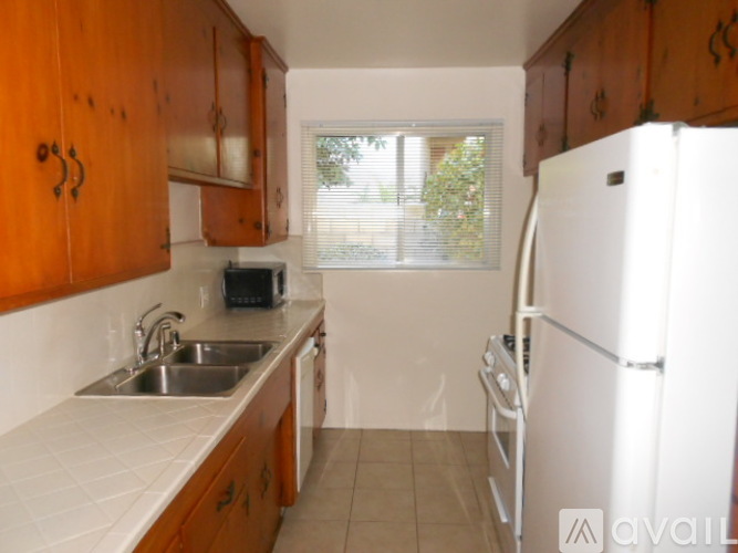 A kitchen with wooden cabinets and a white fridge.