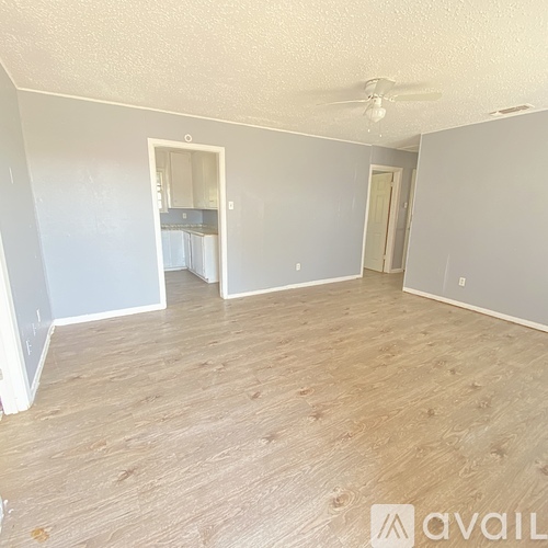 A room with a wooden floor and a ceiling fan.