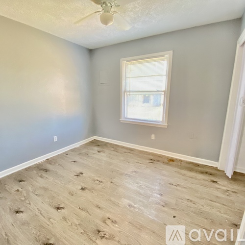 A room with a window and a ceiling fan.
