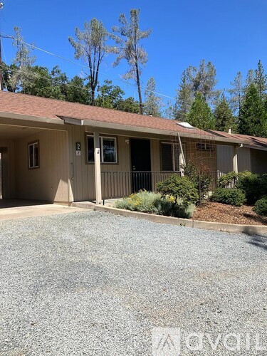 A house with a gravel driveway in front of it.