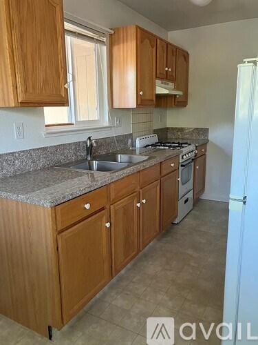 A kitchen with wooden cabinets and a granite countertop.