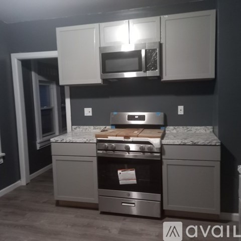A kitchen with a stove top oven and microwave above it.