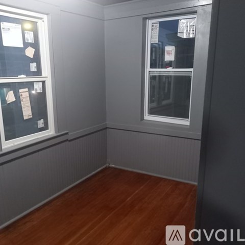 A room with a window and a bulletin board on the wall.