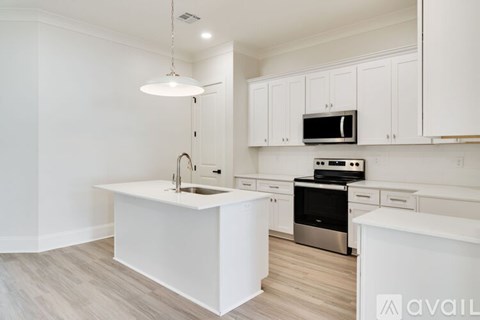 A modern kitchen with white cabinets and a stainless steel oven.