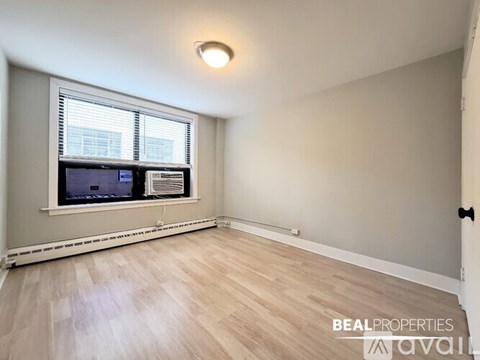 A room with a window and a fan on the window sill.