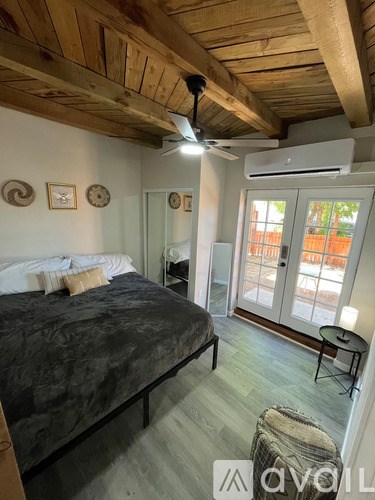 A bedroom with a bed, a chair, and a ceiling fan.