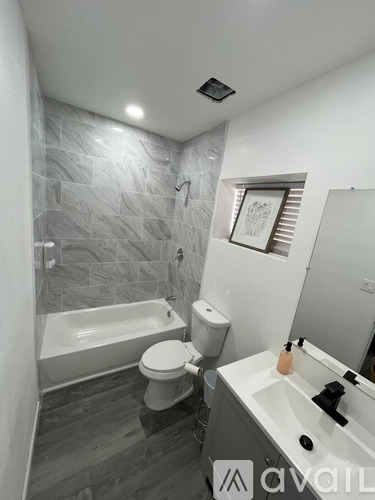 A bathroom with a tub, toilet, and sink.