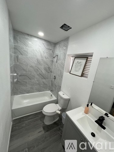 A bathroom with a tub, toilet, and sink.
