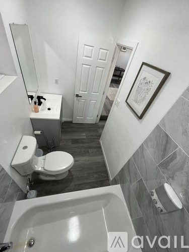 A bathroom with a toilet, sink, and bathtub.