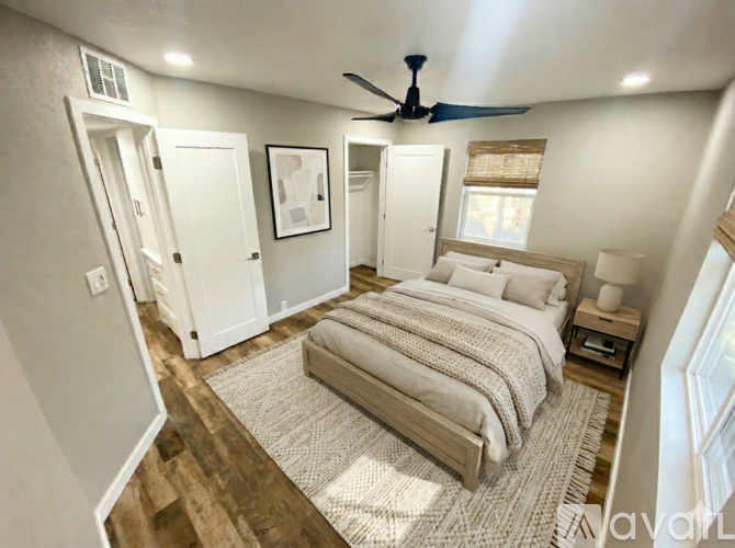 A bedroom with a large bed and a ceiling fan.