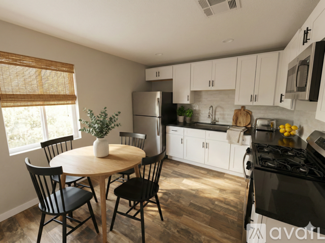 A kitchen with a table and chairs.