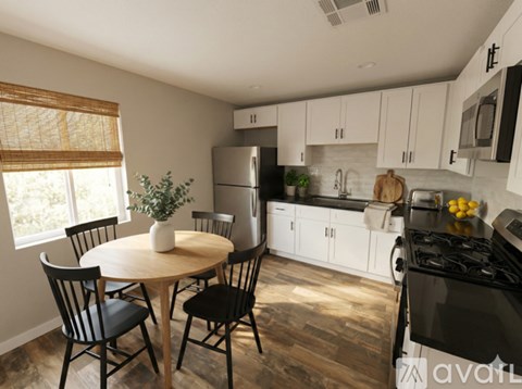 A kitchen with a table and chairs.