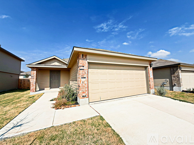 A house with a garage door and a driveway in front.