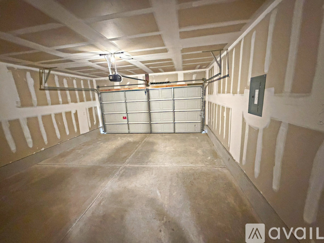 A spacious garage with a closed metal gate in the middle.