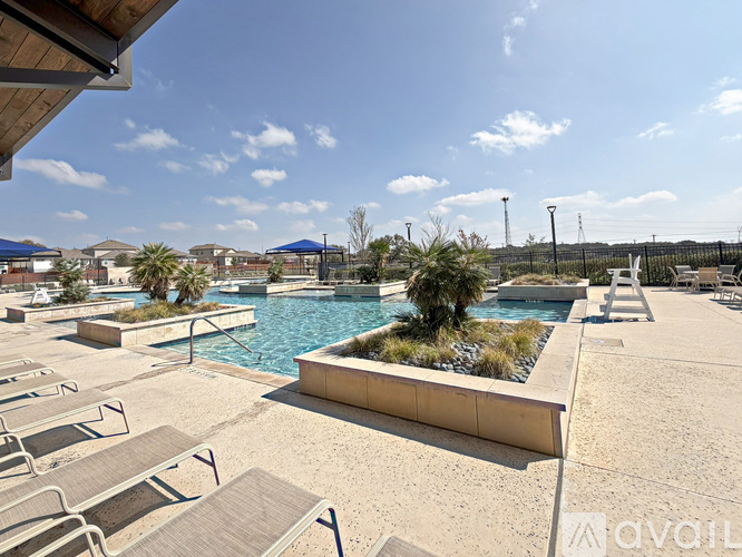 A pool area with sun loungers and a clear blue sky.