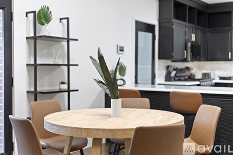 A modern kitchen with a round wooden table and chairs.