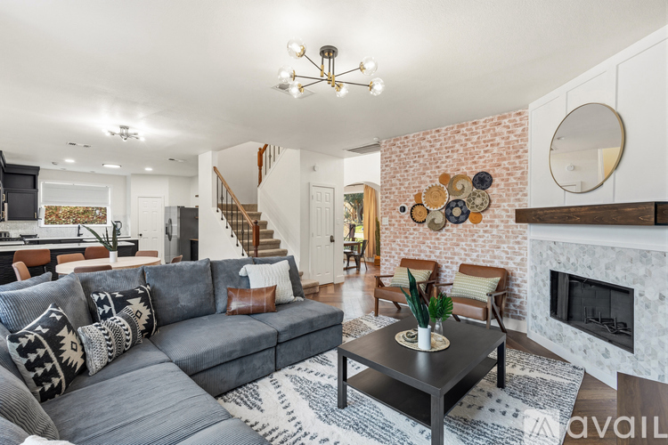 A living room with a grey couch and a fireplace.