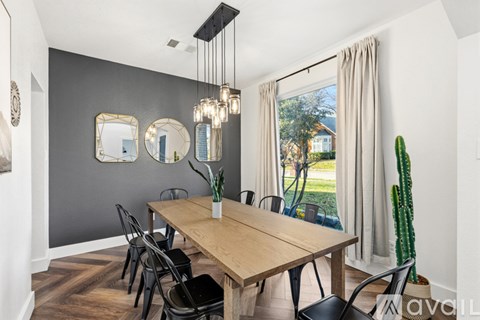 A dining room with a wooden table and chairs.